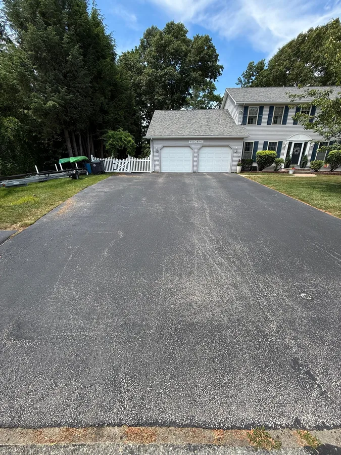 Faded wide residential driveway needing sealcoating