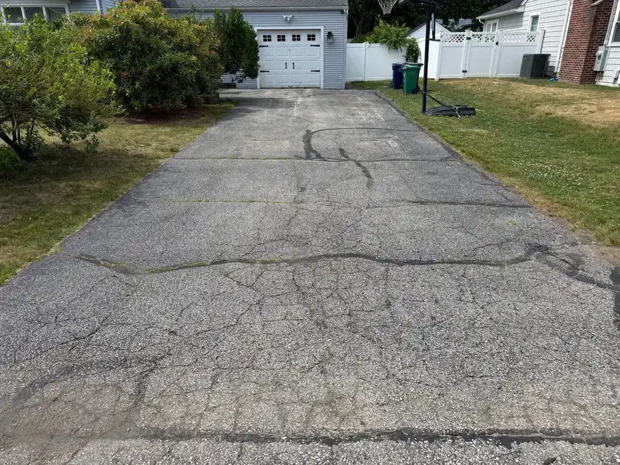 Cracked and deteriorated asphalt pavement showing freeze-thaw damage and UV oxidation