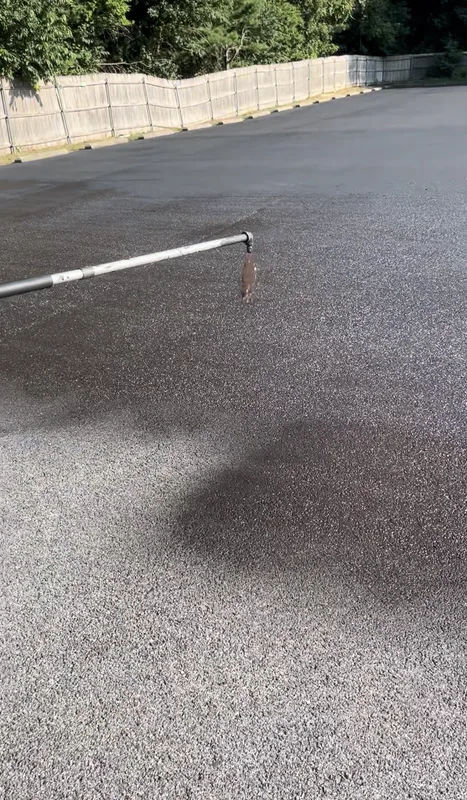 Commercial sealcoating equipment and crew on a parking lot job