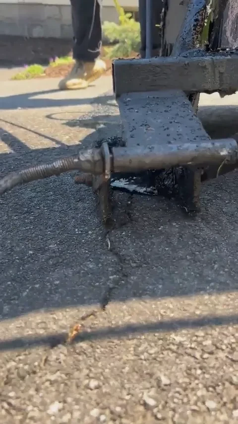 Hot rubberized crack filling applied to asphalt