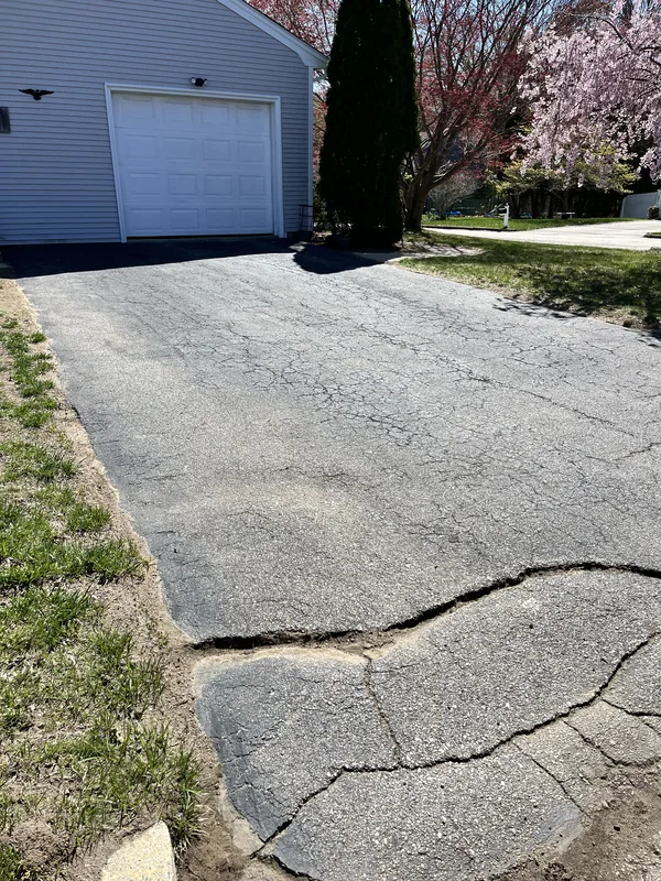 Asphalt surface showing cracks requiring inspection and cleaning before treatment