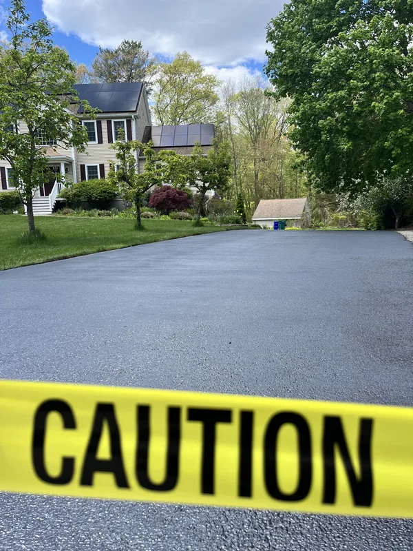 Close-up of freshly sealed asphalt surface texture with hand-brushed finish
