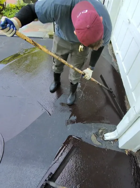 Titan Enterprises crew applying sealcoating to residential driveway