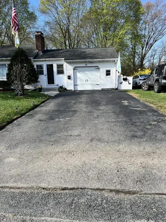 Oxidized and faded residential driveway showing UV damage and surface deterioration before sealcoating