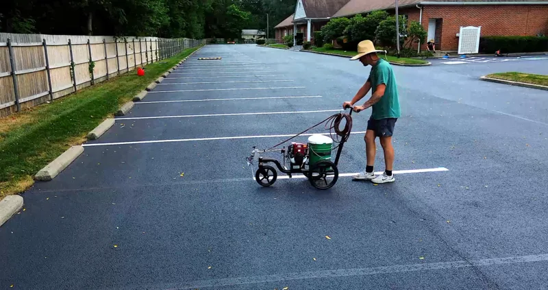 Line striping machine applying precise parking lot markings